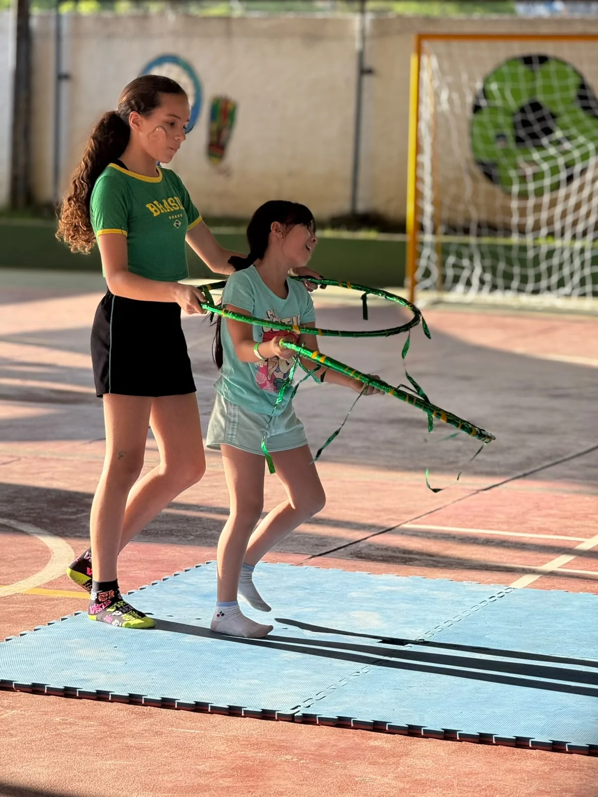 Atividade em dupla com bambolês na quadra